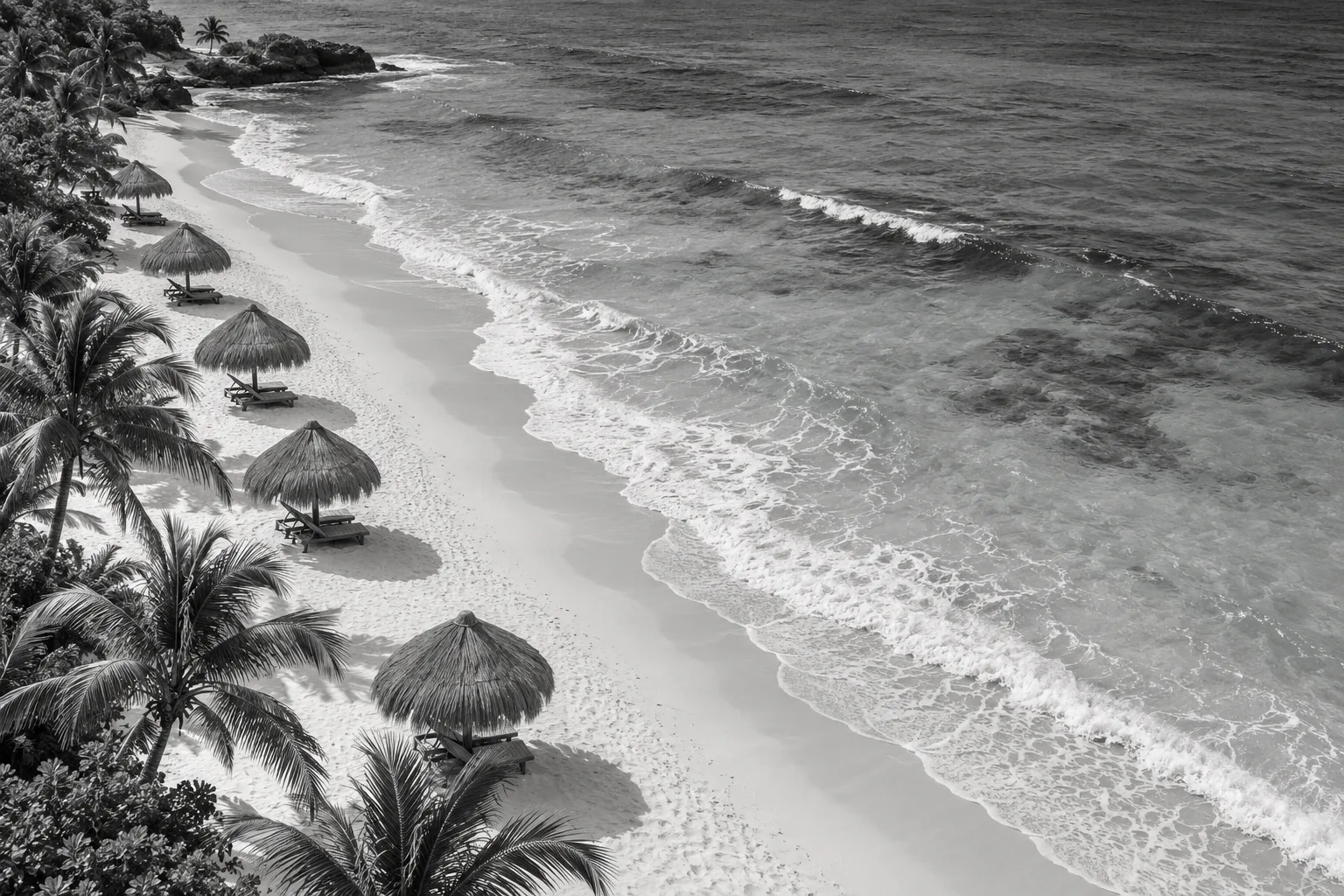 Vista aérea de una playa caribeña con palapas junto a la orilla